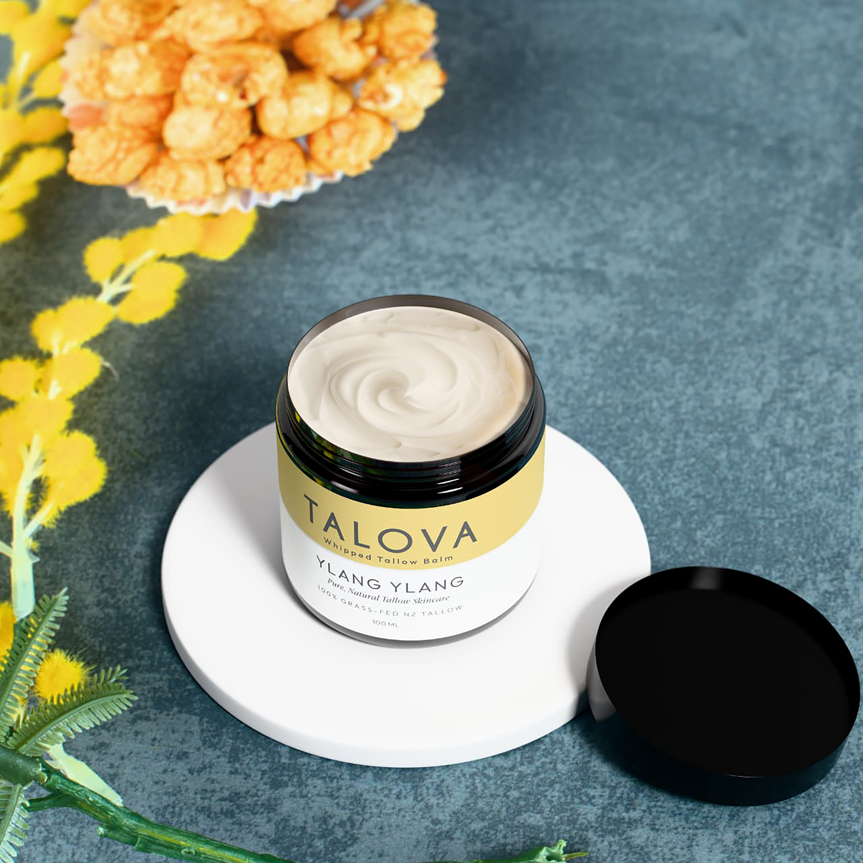 Talova ylang ylang whipped tallow balm 100ml open jar with flowers moody background